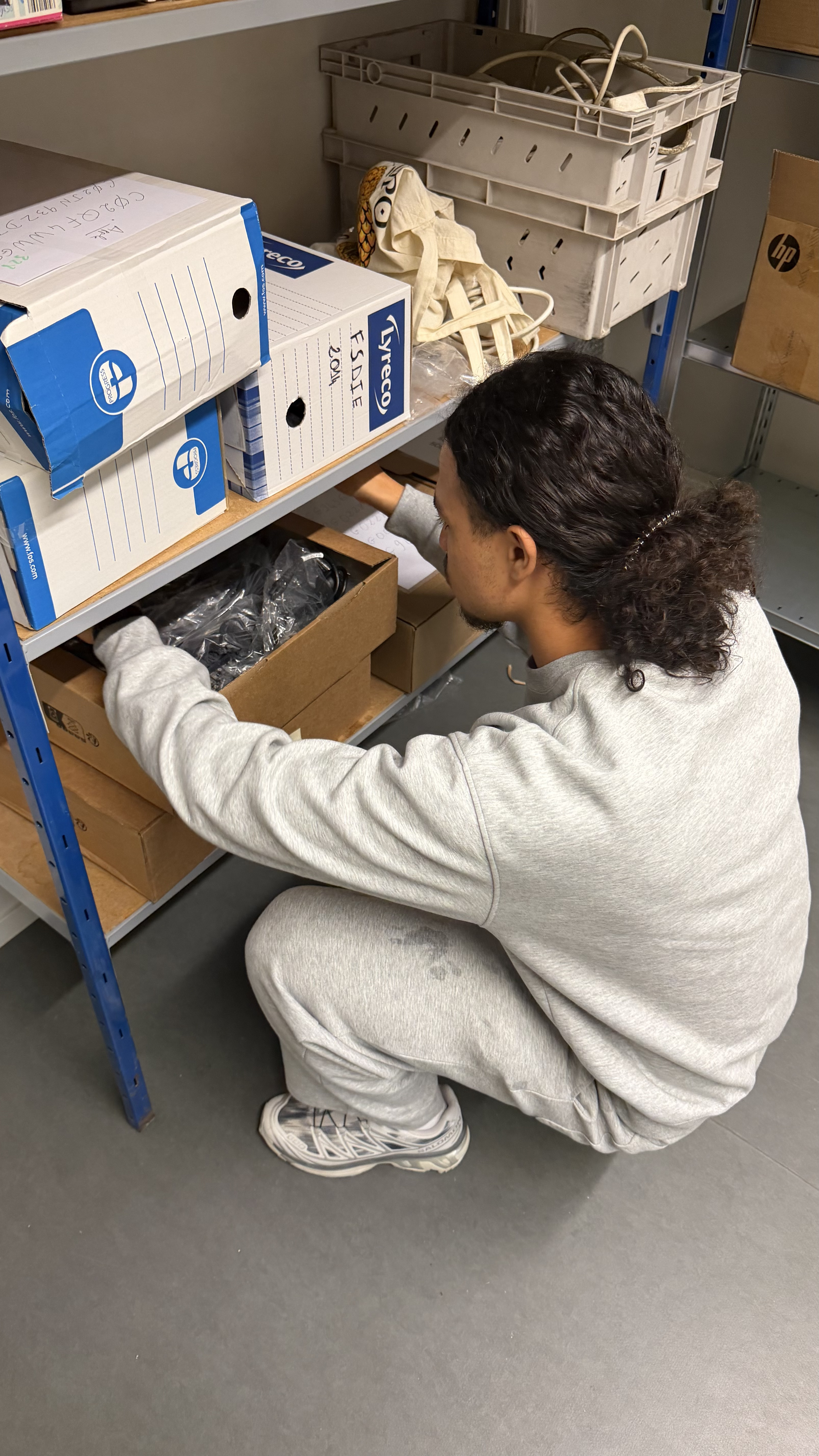 Un agent de la ressourcerie en plein travail, il récupère un ordinateur dans ses stocks.